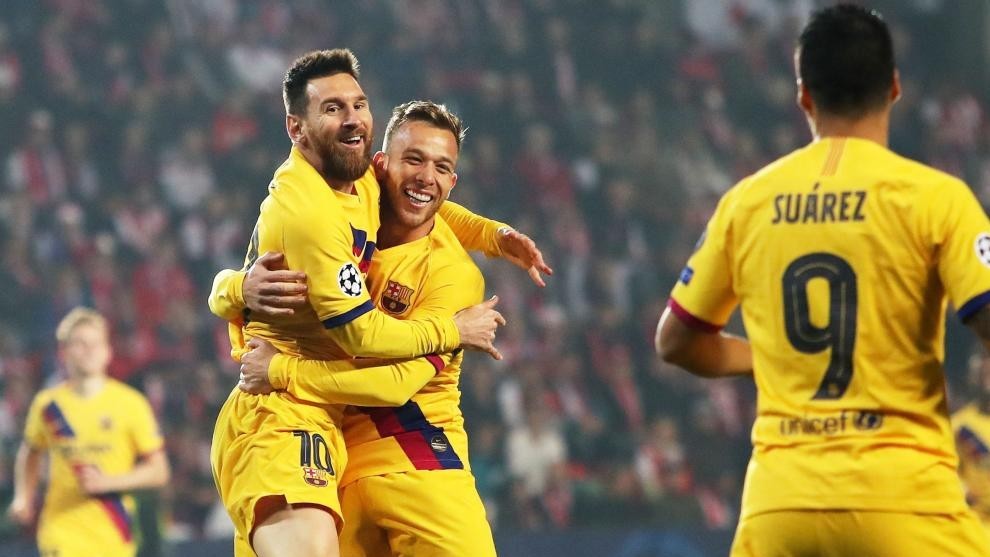 Messi y Arthur se abrazan ante la mirada de Luis Surez en un partido...