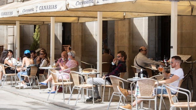 Una terraza en Barcelona con clientes en las mesas.