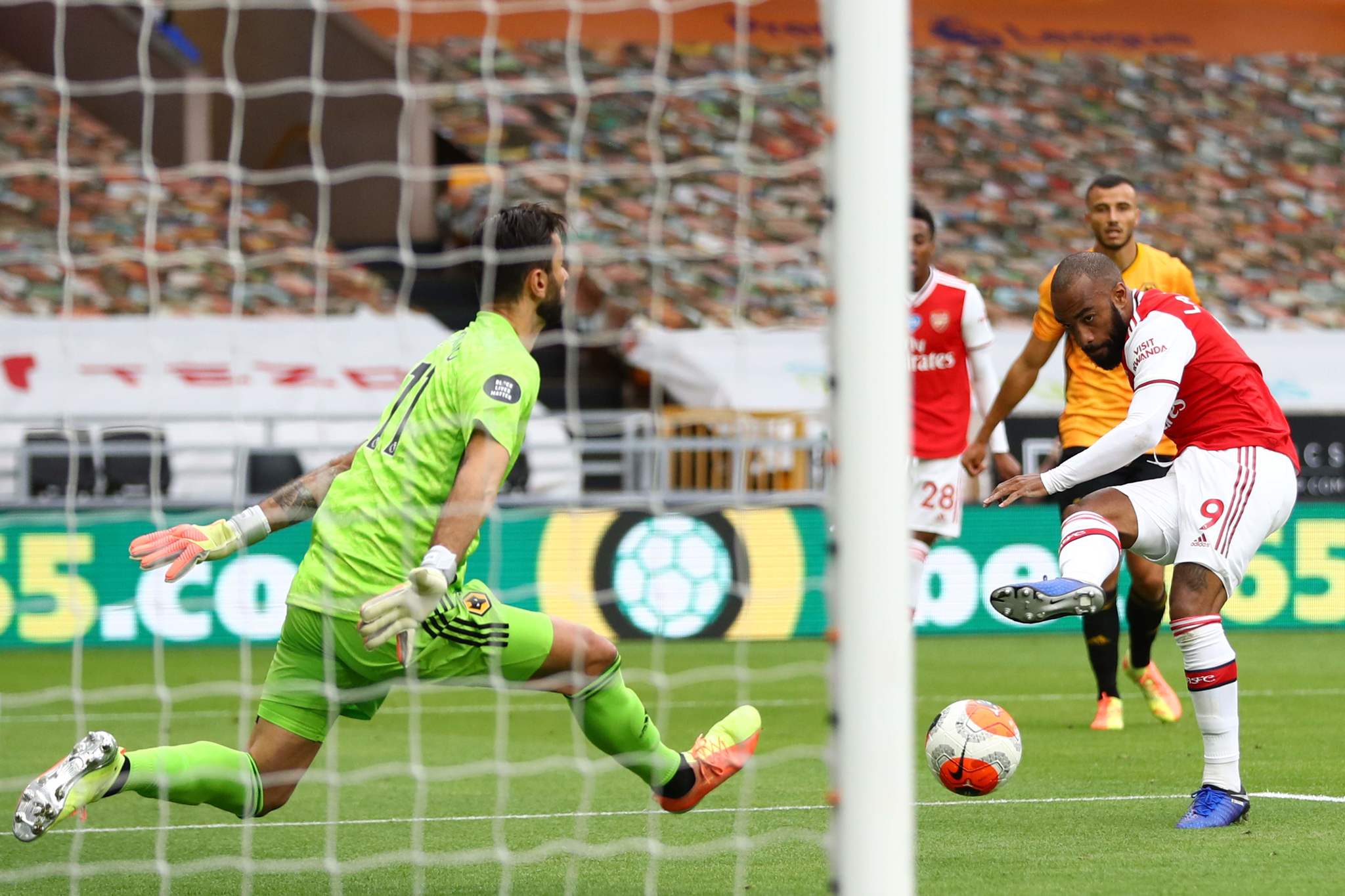 Arsenals French striker Alexandre lt;HIT gt;Lacazette lt;/HIT gt; (R) scores their second goal during the English Premier League football match between Wolverhampton Wanderers and Arsenal at the Molineux stadium in Wolverhampton, central England on July 4, 2020. (Photo by Michael Steele / POOL / AFP) / RESTRICTED TO EDITORIAL USE. No use with unauthorized audio, video, data, fixture lists, club/league logos or live services. Online in-match use limited to 120 images. An additional 40 images may be used in extra time. No video emulation. Social media in-match use limited to 120 images. An additional 40 images may be used in extra time. No use in betting publications, games or single club/league/player publications. /