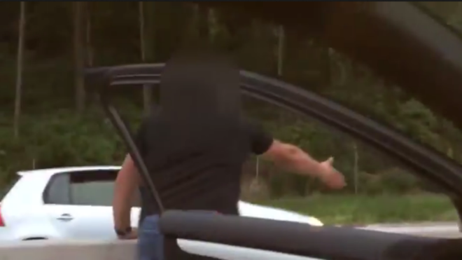 Un hombre sale de su coche para avisar a otro de que va en sentido contrario.