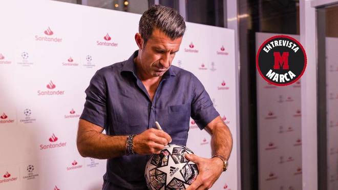 Luis Figo firmando un balón en el &apos;Santander Media House&apos; de Lisboa.
