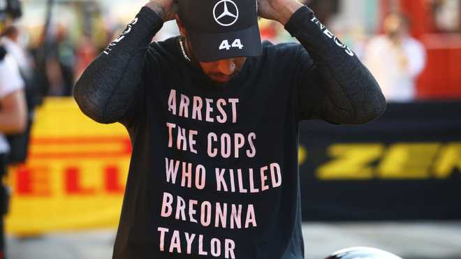As luci Lewis Hamilton la camiseta en el podio del GP Toscana.