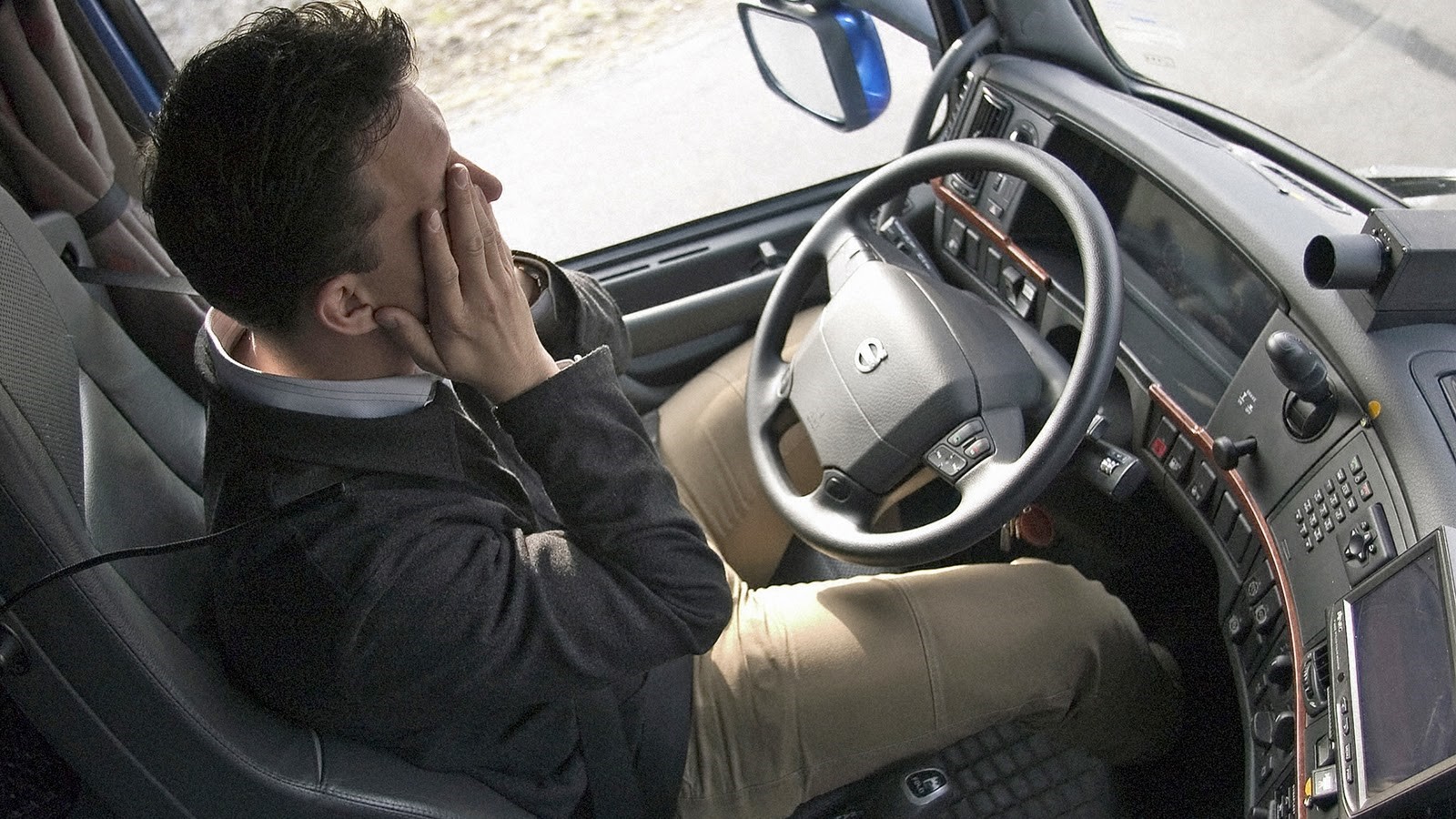Un transportista se frota los ojos para combatir el cansancio.