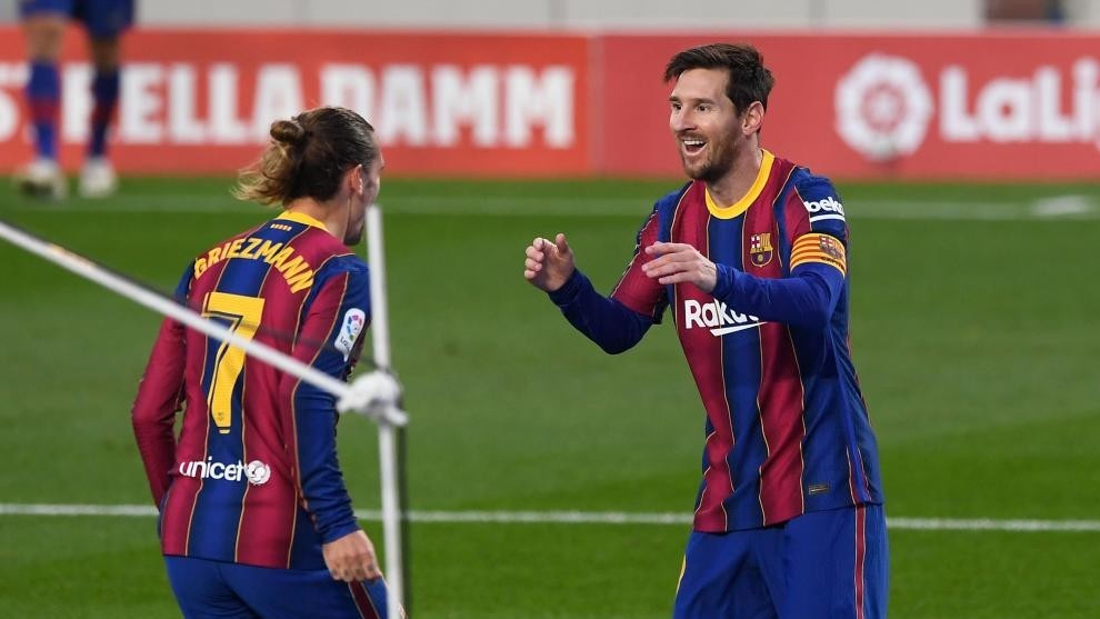 Griezmann y Messi se abrazan en un partido del Barcelona.