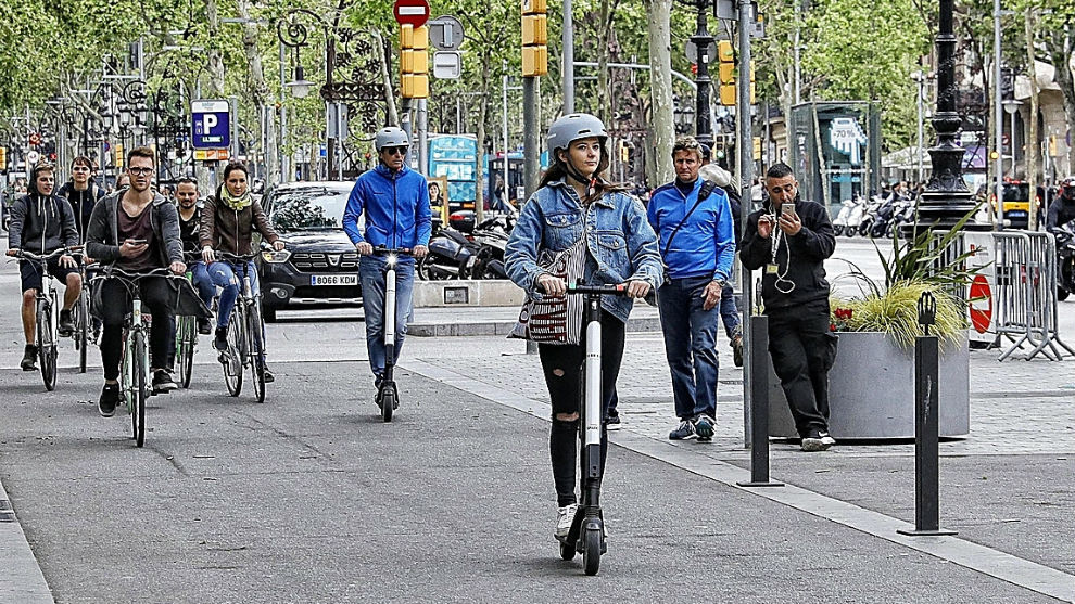 Varias personas circulan en patinete y bicicleta por el paseo de Gracia de Barcelona. Foto: Santi Cogolludo