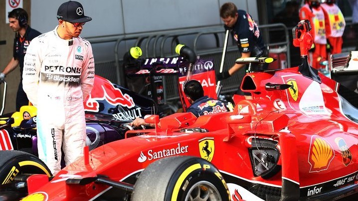 Hamilton mira un coche de Ferrari.