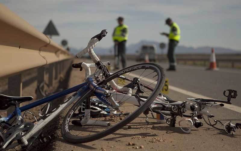 Dos agentes recaban pruebas en el lugar de un atropello a dos ciclistas.