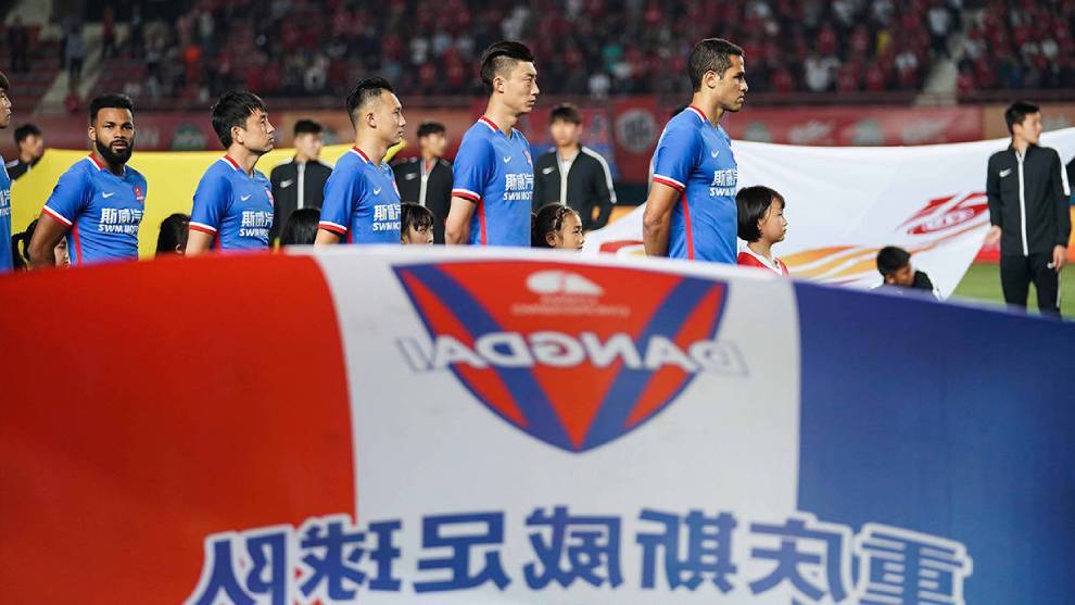 Los futbolistas del Chongqing Dangdai Lifan escuchan el himno antes de un partido de la Superliga.