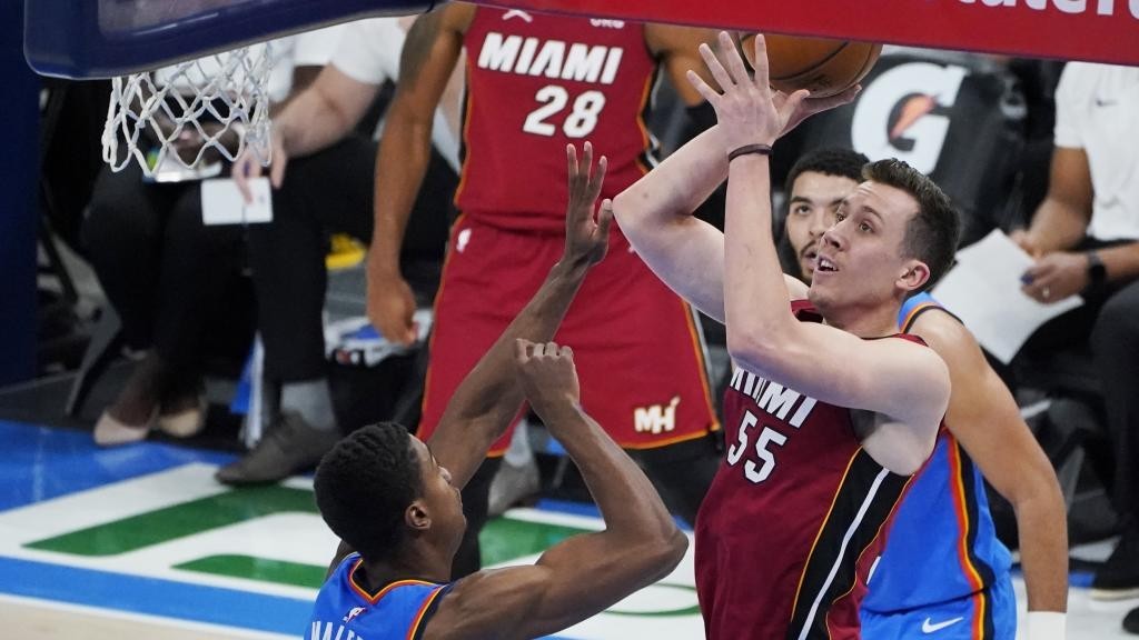 Duncan Robinson lanza entre Theo Maledon y Kenrich Williams.