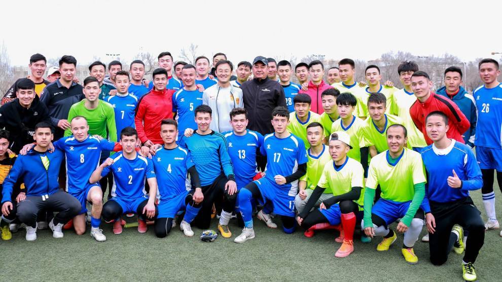 Sun Jihai (en el centro) posa con futbolistas de Xinjiang tras un torneo de ftbol