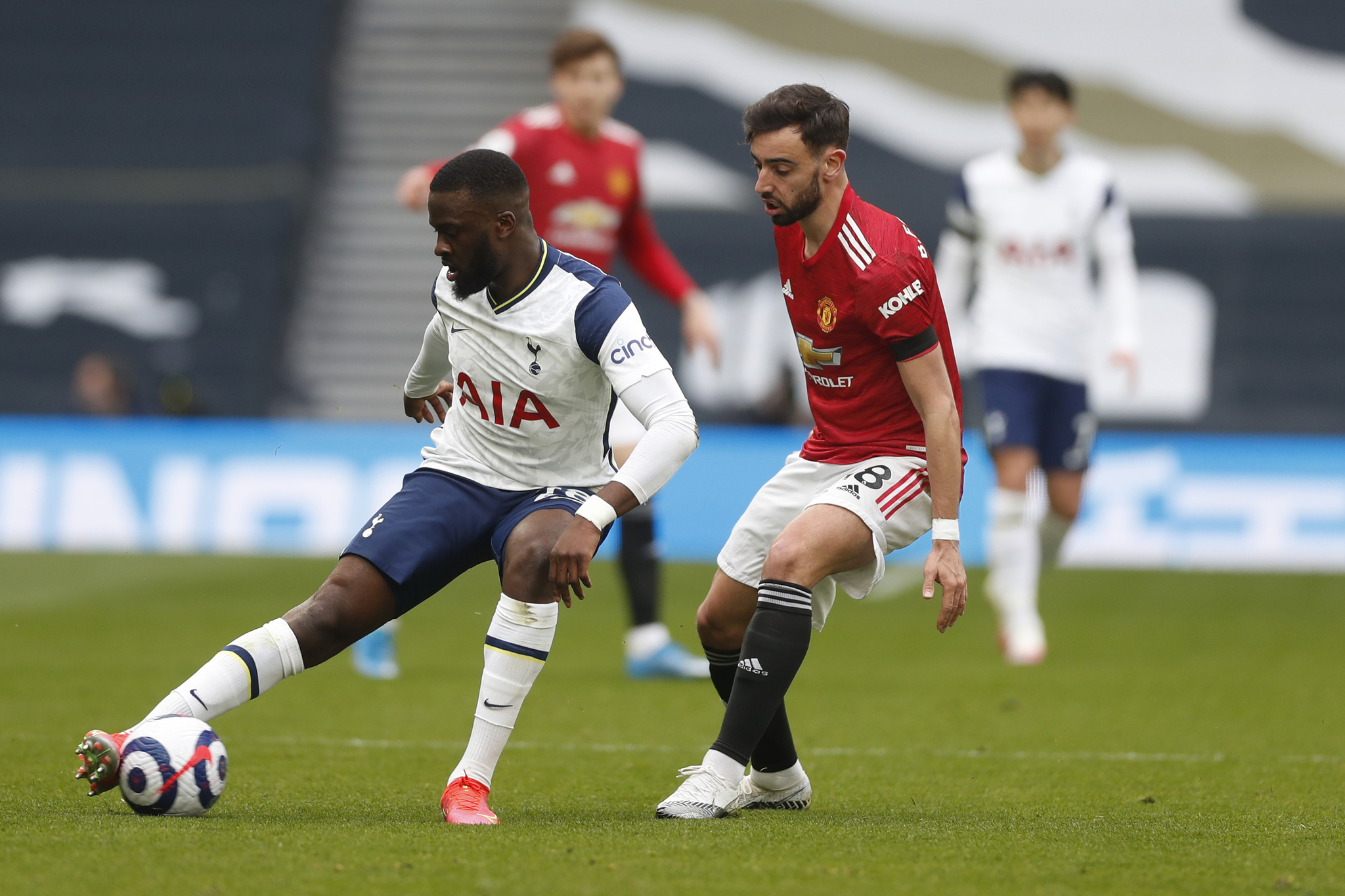Tanguy Ndombele  challenged by Manchester United's Bruno Fernandes