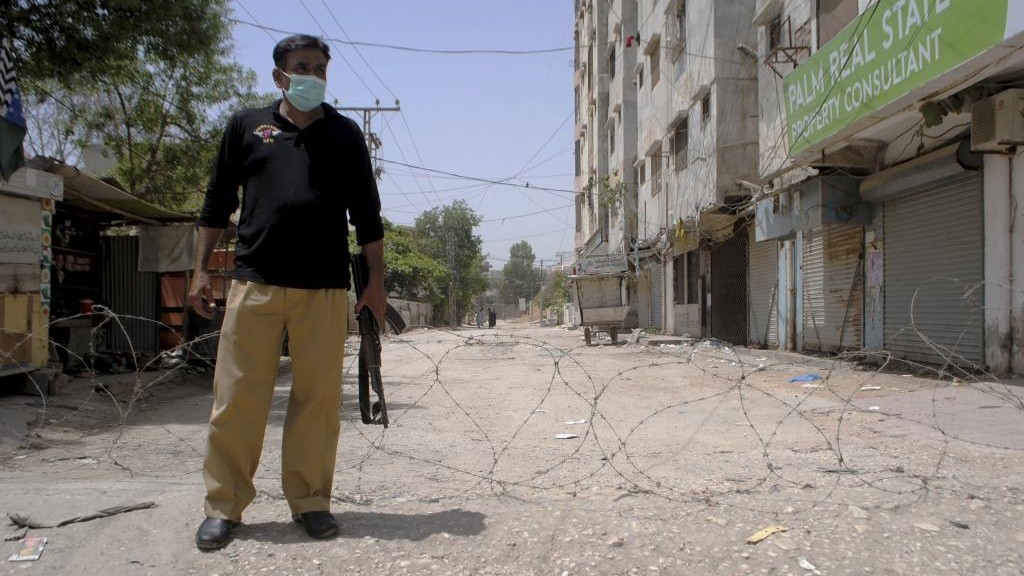 Un polica monta guardia en una zona restrigida por el coronavirus en Pakistn