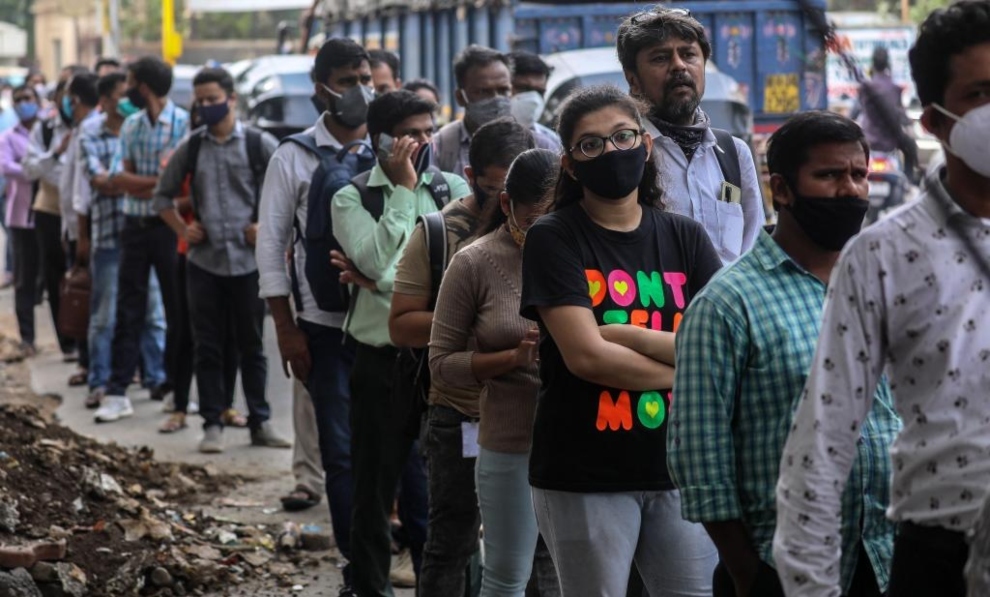 Los ciudadanos indios se alinean con sus máscaras obligatorias en medio de una crisis pandémica.