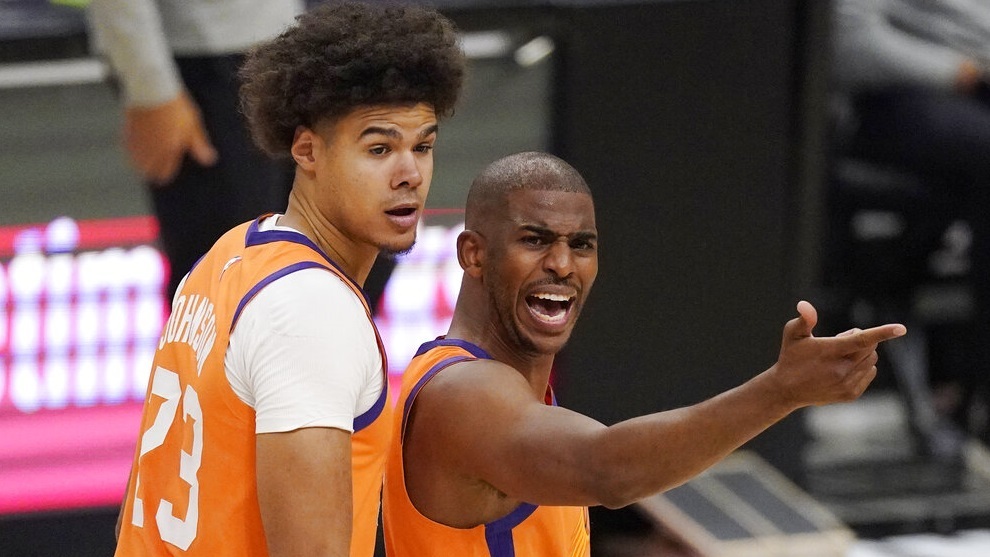 Phoenix Suns guard Chris Paul, right, complains to a referee about a call as forward Cameron Johnson looks on.