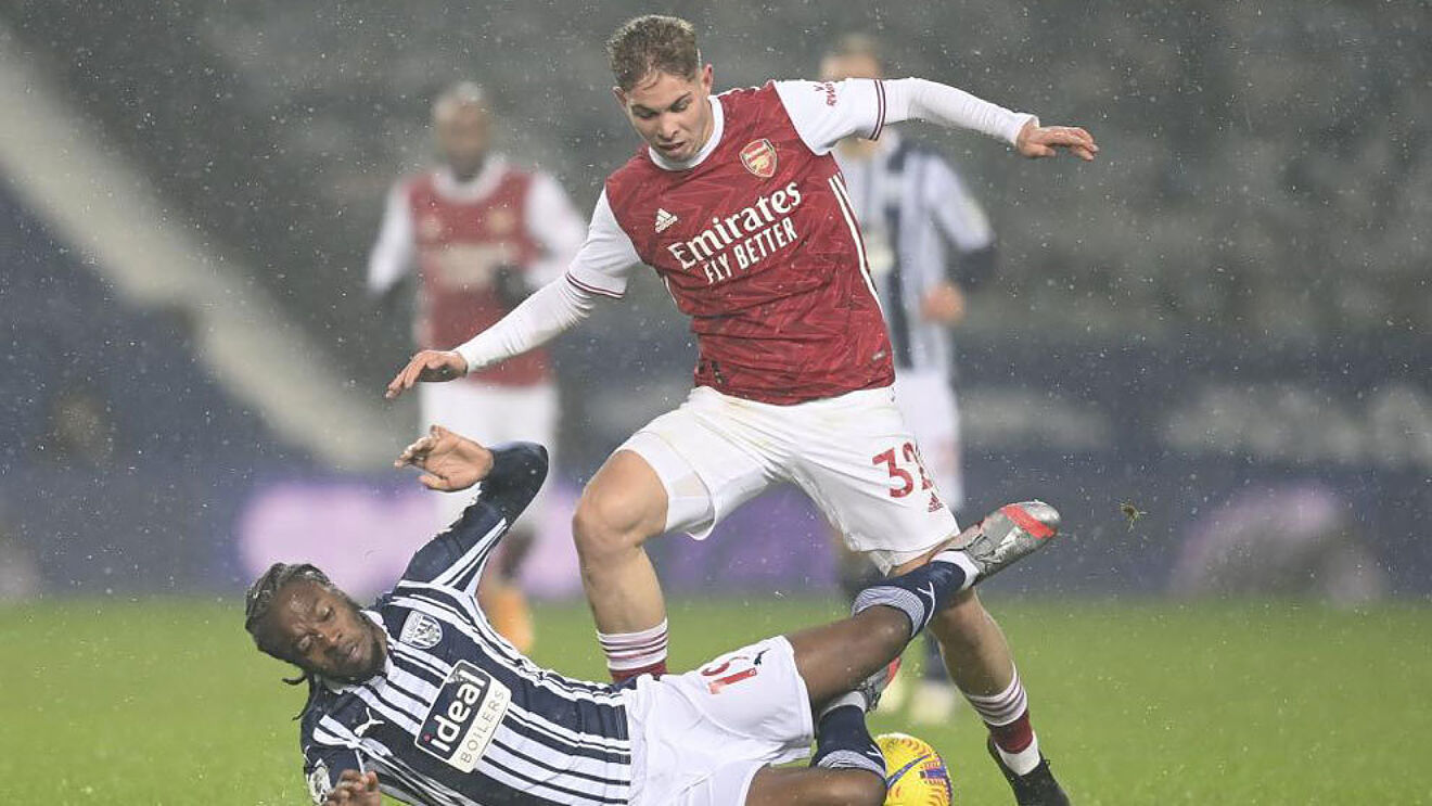 Smith Rowe bajo la lluvia en un encuentro con el Arsenal.