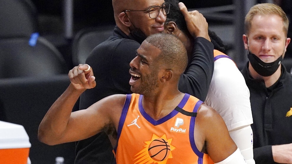 Phoenix Suns head coach Monty Williams, left, hugs Jae Crowder, second from right, while guard Chris Paul celebrates as time runs out in Game 6.