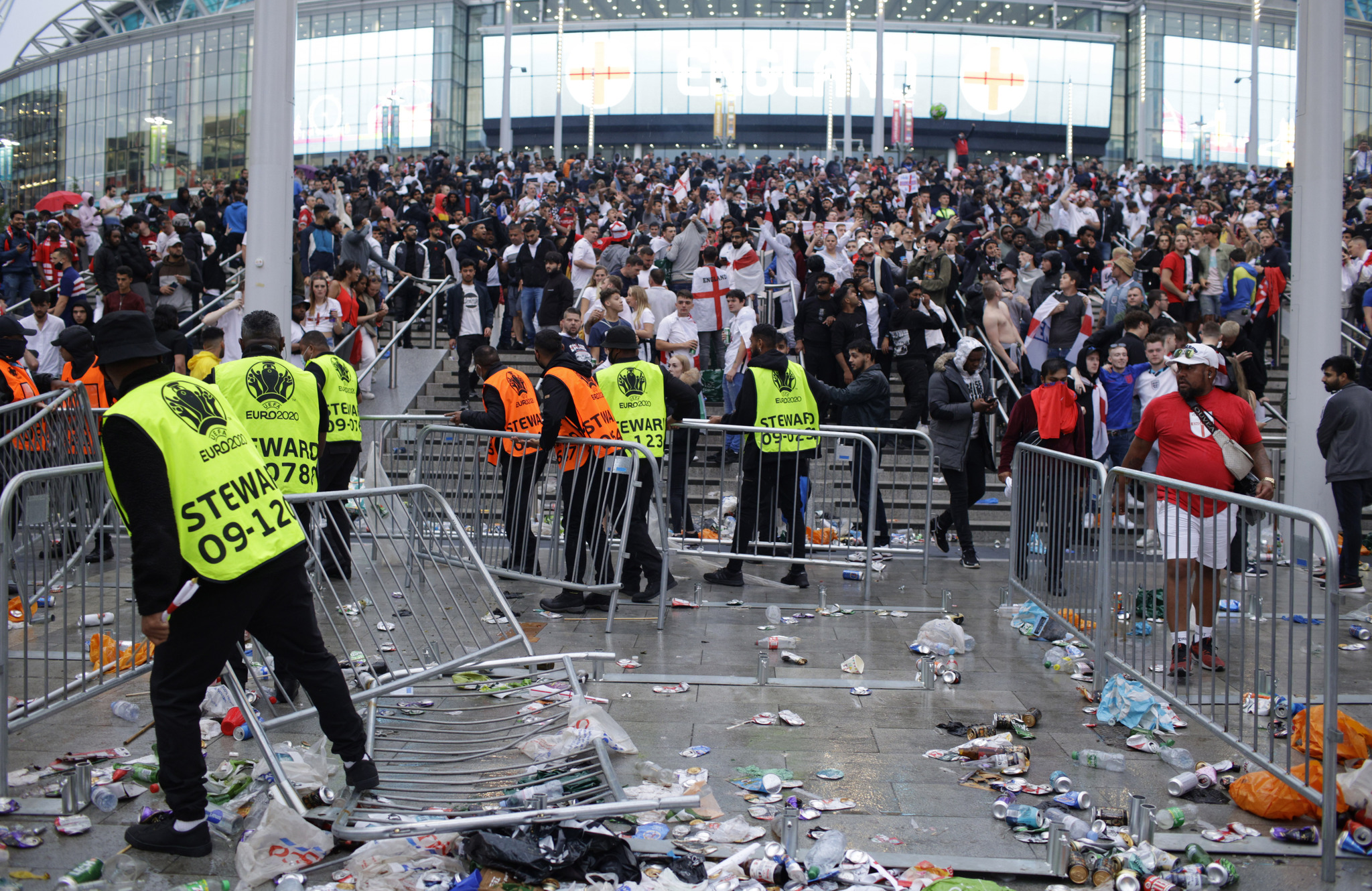 Stewards replace barricades after they were knocked over by supporters outside Wembley Stadium