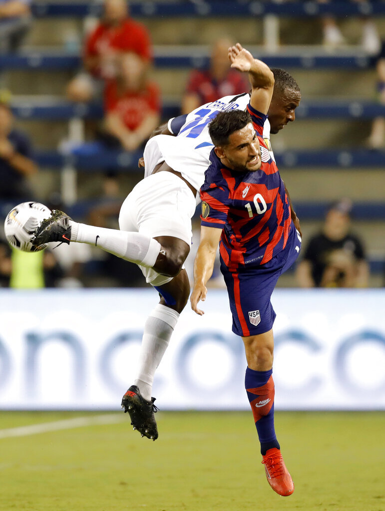 Martinique defender Sebastien Cretinoir (21) and U.S. midfielder Cristian Roldan (10) collide after attempting to head the ball.