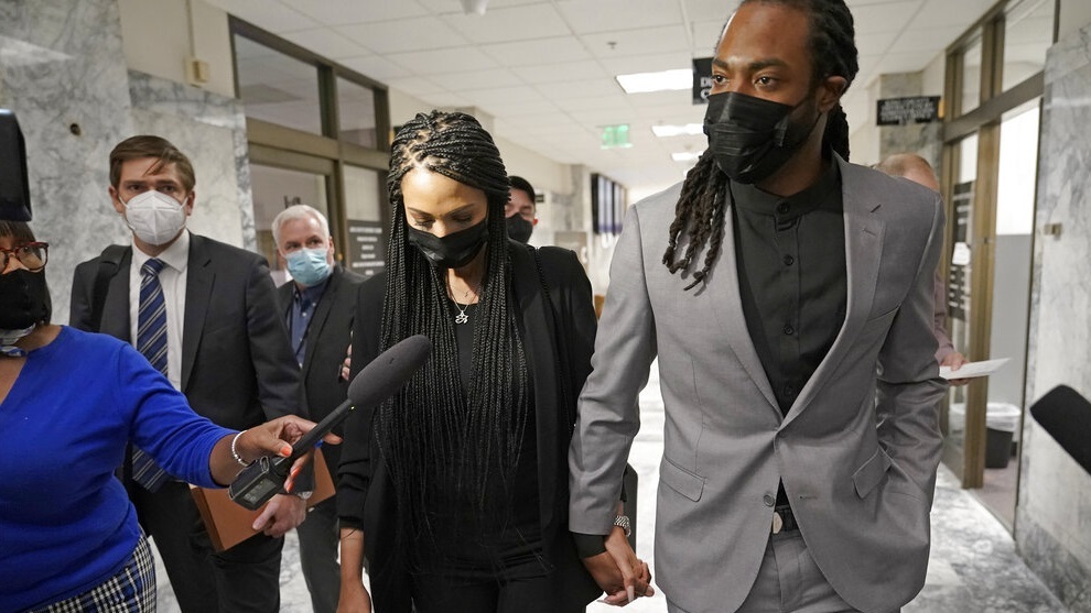 Richard Sherman walks with his wife Ashley following a King County District Court hearing in Seattle.