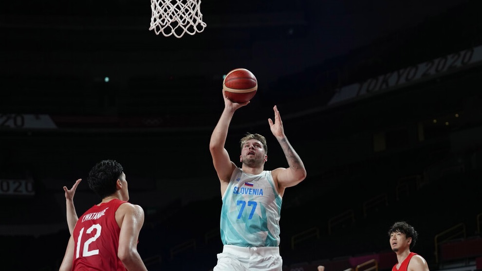 Slovenia's Luka Doncic (77) drives to the against Japan's Yuta Watanabe (12).