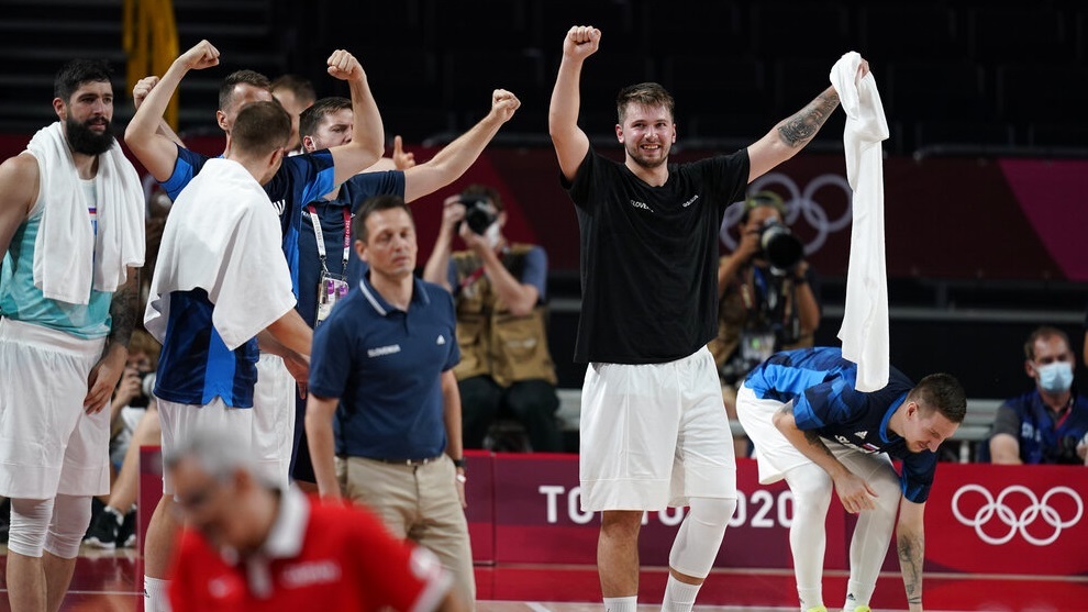 Slovenia's Luka Doncic (77), right, and teammates celebrate on the bench.