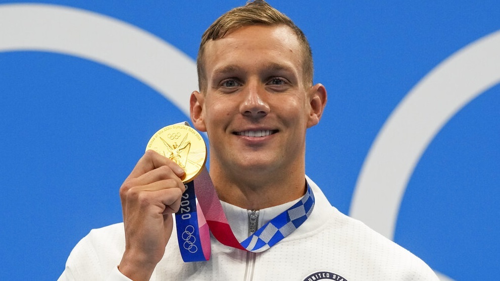 Dressel poses after winning the gold medal in the men's 100-meter butterfly final.