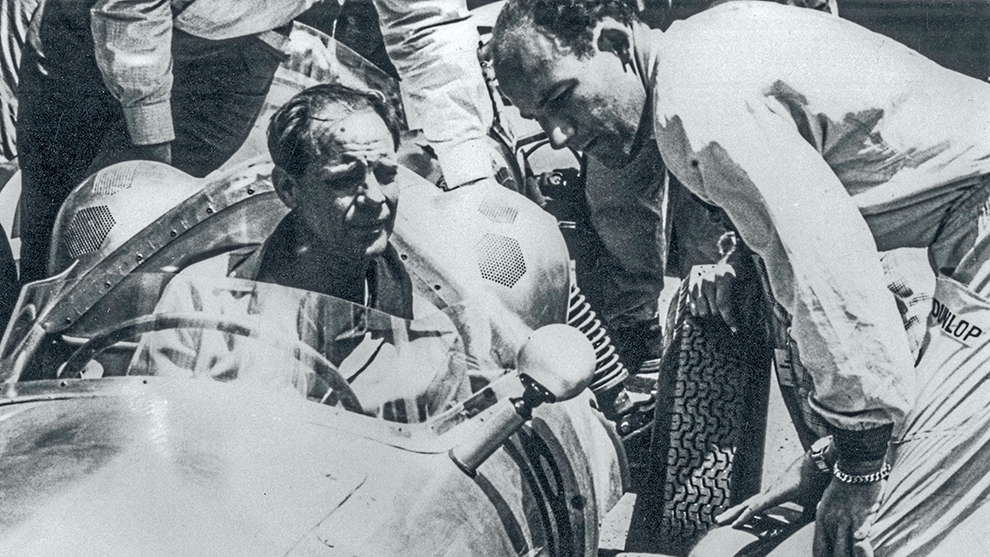 Bill Jennings, al volante de su propio vehculo, habla con Stirling Moss.