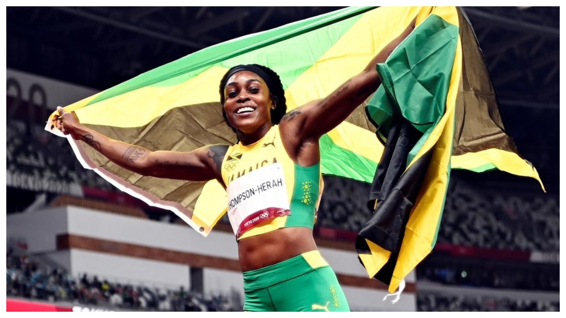 Elaine Thompson con la bandera de Jamaica.
