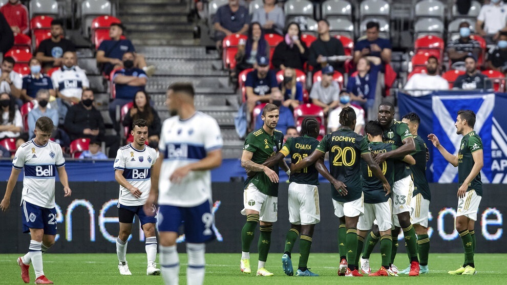 Portland Timbers players celebrate after a Vancouver Whitecaps own goal.