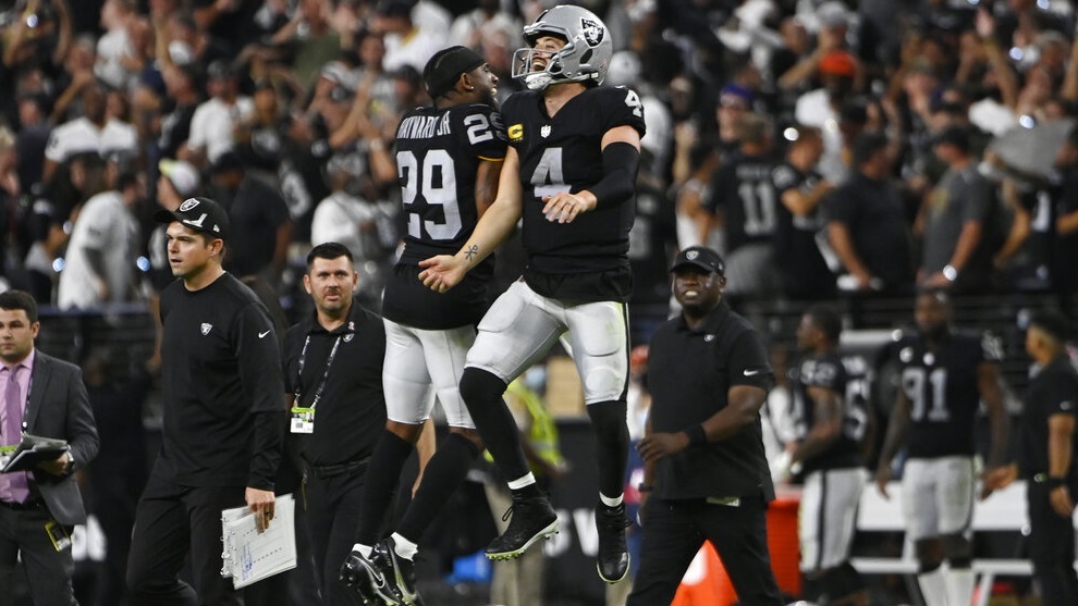 Casey Hayward (29) and Derek Carr (4) celebrate after defeating the Baltimore Ravens.