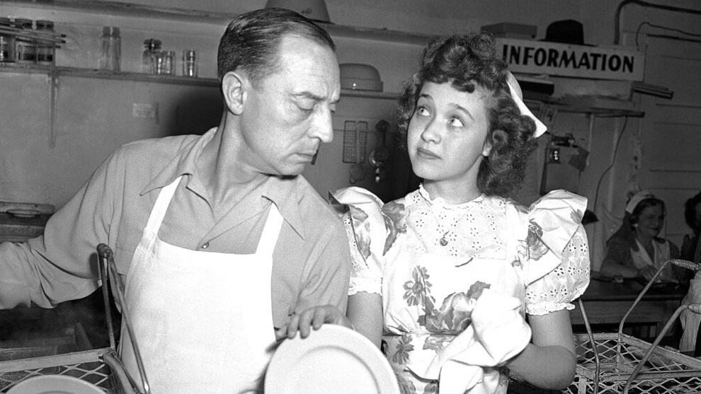 Jane Powell, who just completed work in "Song of the Open Road" does her bit at the canteen drying dishes for dishwasher Buster Keaton.