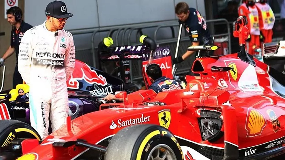 Hamilton ejerce de 'espía' mirando un coche de Ferrari.