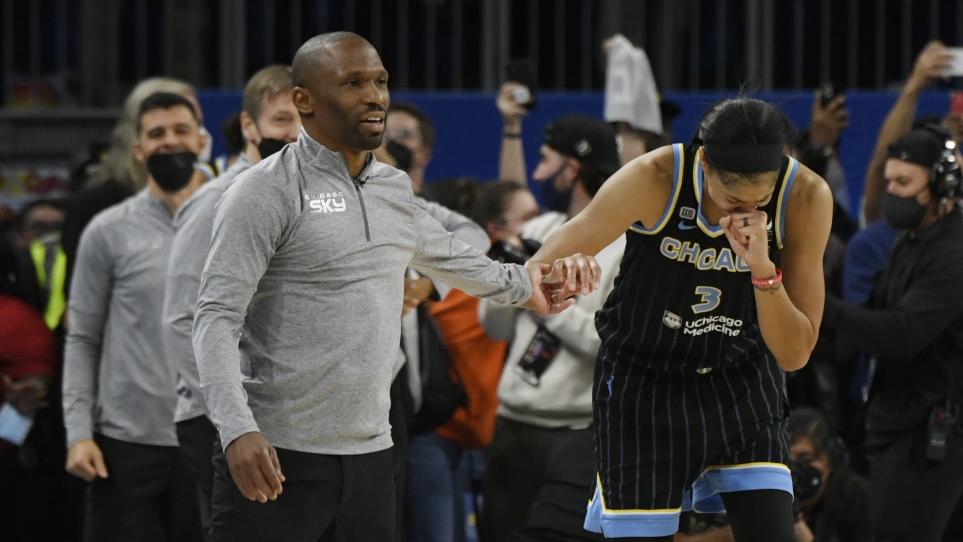 Chicago Sky's Candice Parker (3) reacts while head coach James Wade, left, holds her hand.