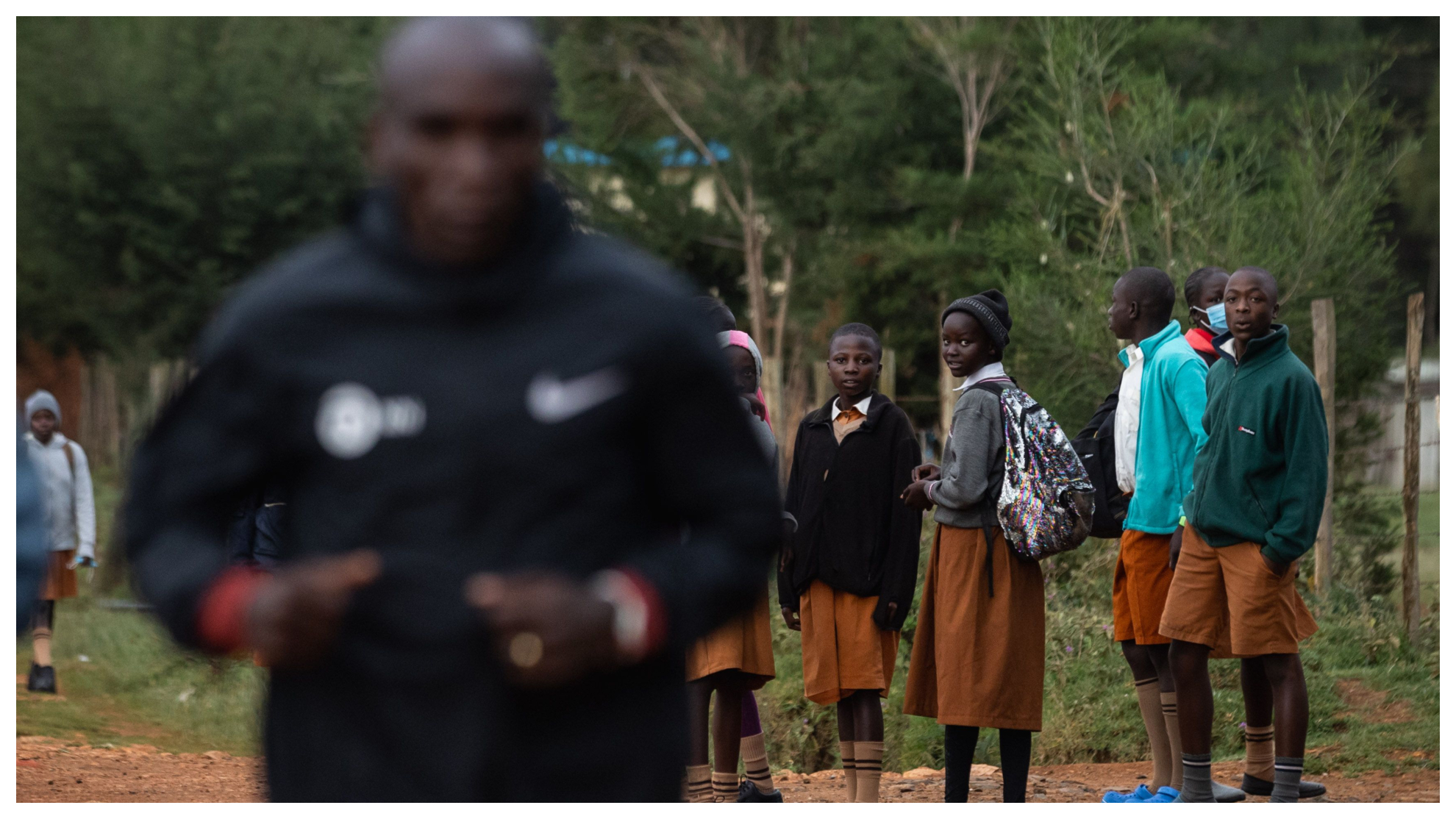 Niños de la zona de Eldoret miran a Kipchoge mientras se dirigen a la escuela.
