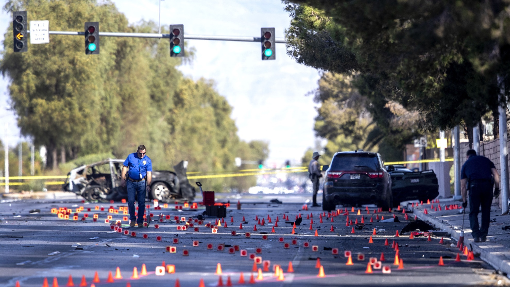 Las Vegas Metro Police investigators take measurements at the scene of a fatal crash.