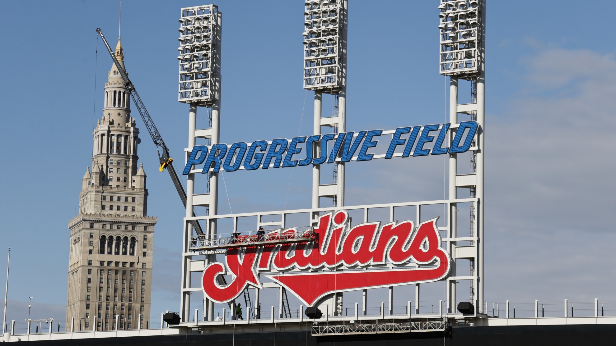 Workers begin to remove the Cleveland Indians sign from above the scoreboard at Progressive Field.