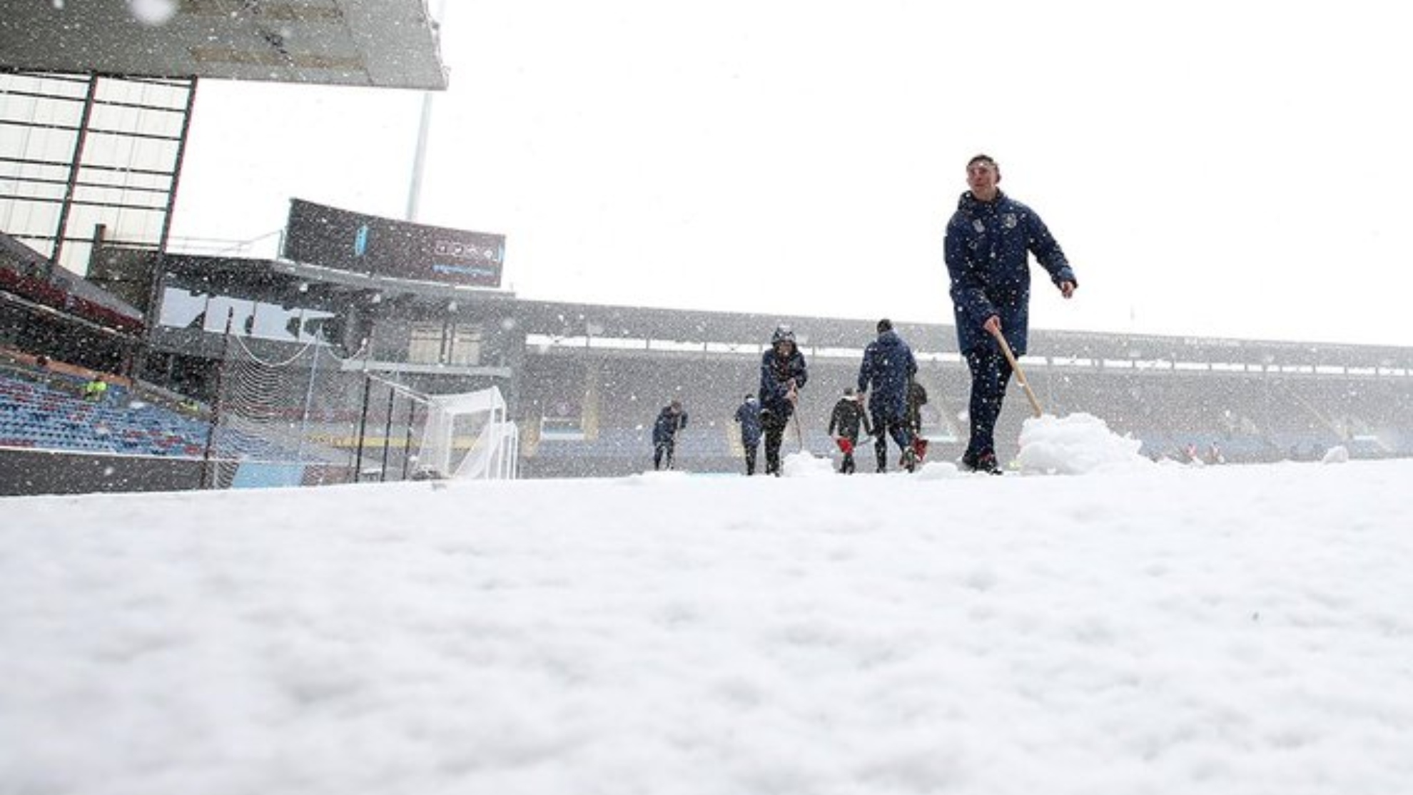 Operarios del Burnley quitando la nieve del estadio Tur Moor.