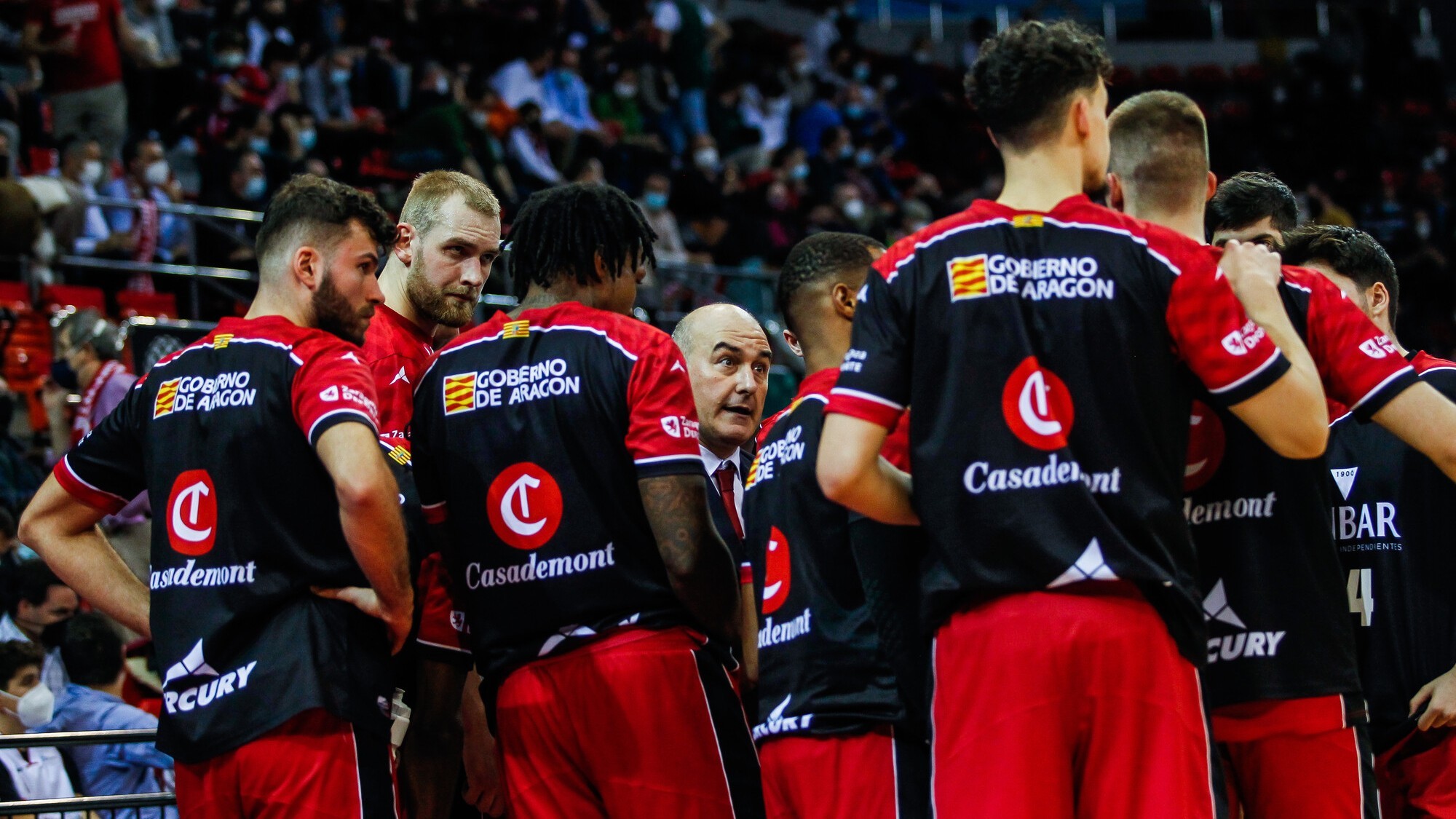 Los jugadores del Casademont Zaragoza atienden a su entrenador Jaume Ponsarnau.