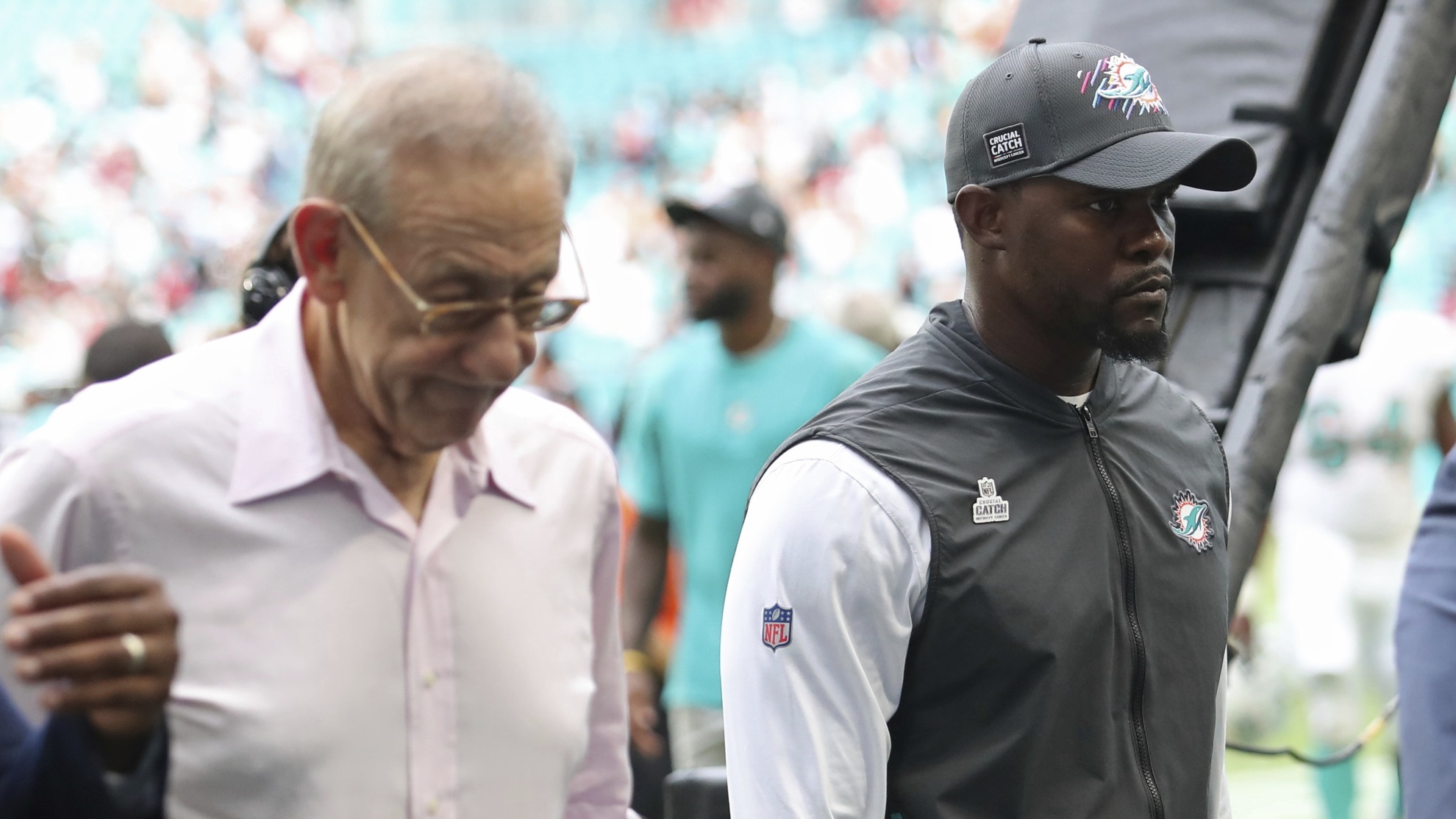 Miami Dolphins owner Stephen Ross walks off the field next to coach Brian Flores.