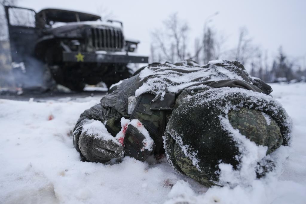Un soldado ruso caído cerca de su vehículos lanzacohetes, cerca de una ciudad ucraniana