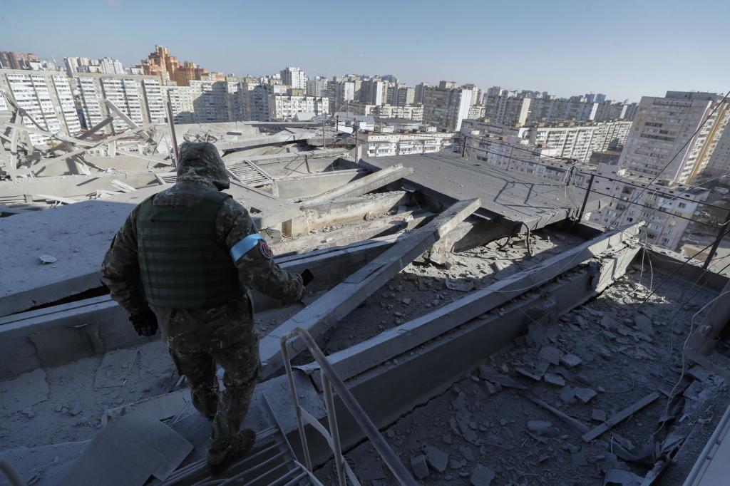Un soldado inspecciona los efectos de un bombardeo sobre un edificio en Kiev