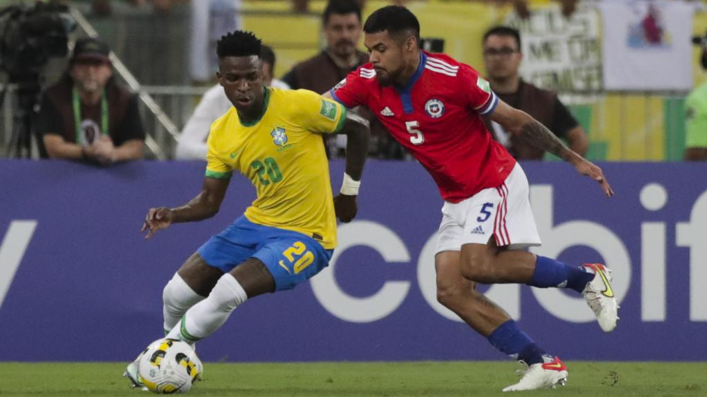 Vinicius, presionado por Isla, conduce el balón en el partido ante Chile.