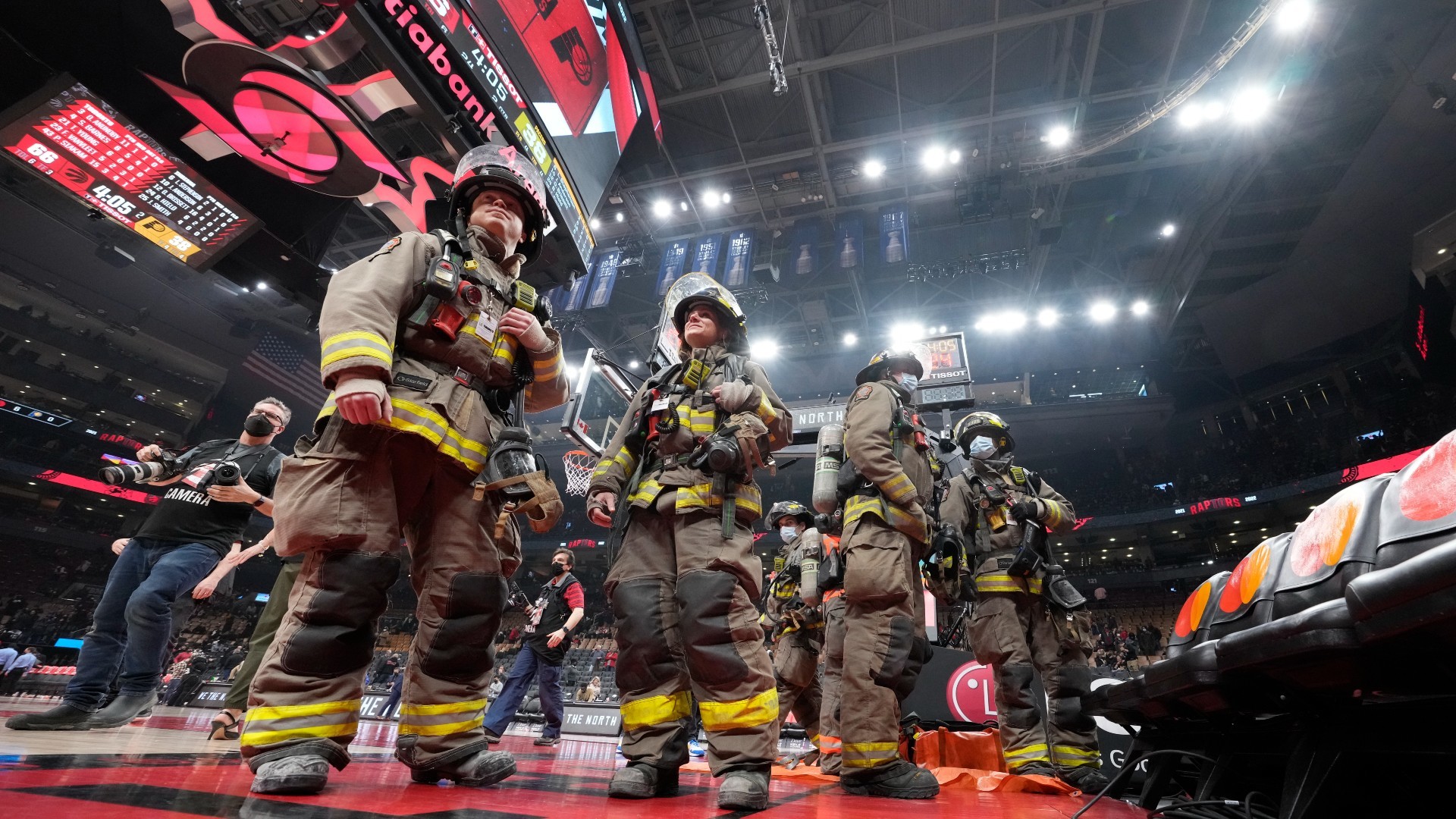 Un grupo de bomberos, sobre el parqué del Scotiabank Arena.