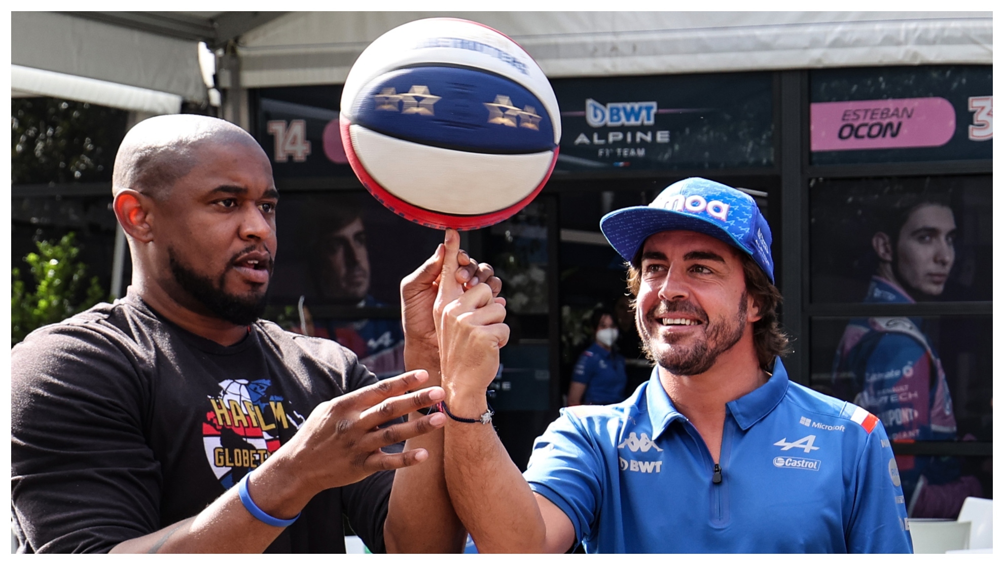 Fernando Alonso, con un balón de baloncesto y un jugador de los Harlem Globe Trotters.