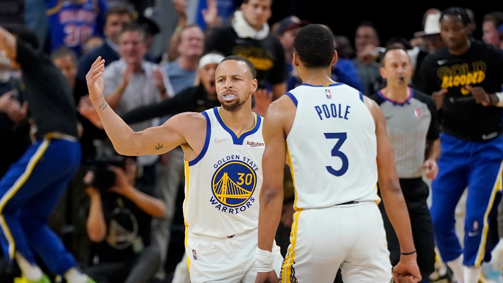 Stephen Curry celebra un triple de los Warriors con Jordan Poole.