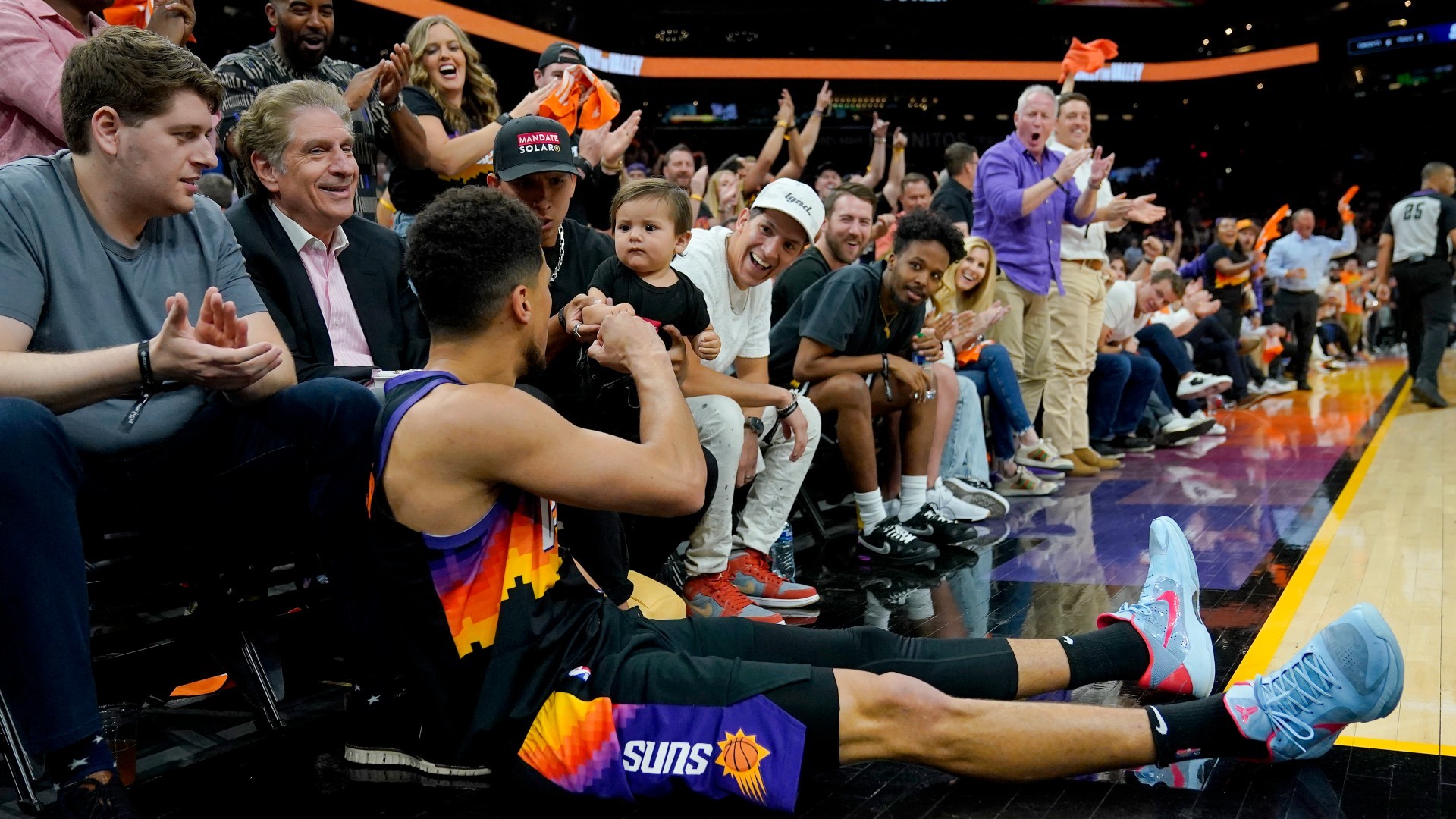 Booker celebra un triplazo con el aficionado más joven de los Suns