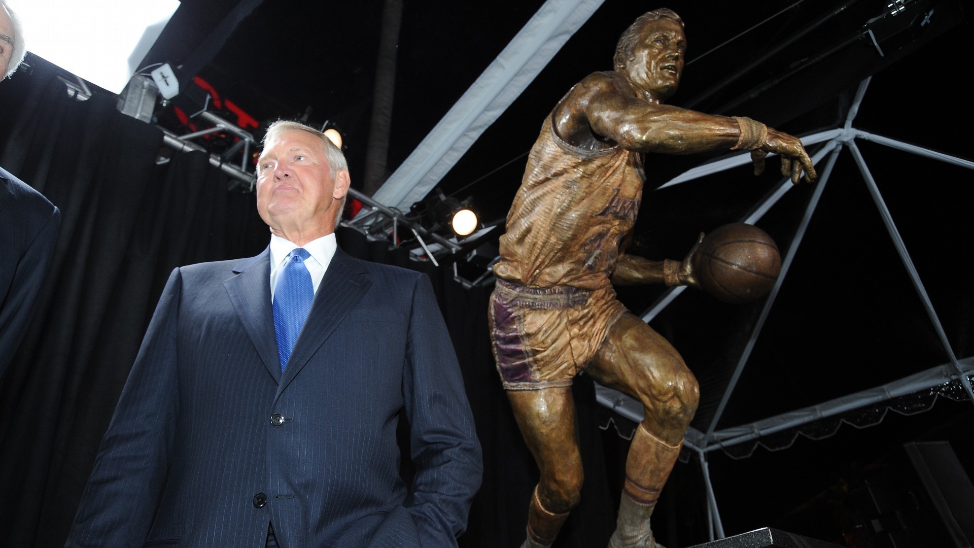 Jerry West posa delante de la estatua que tiene a la puerta del pabelln de los Lakers.