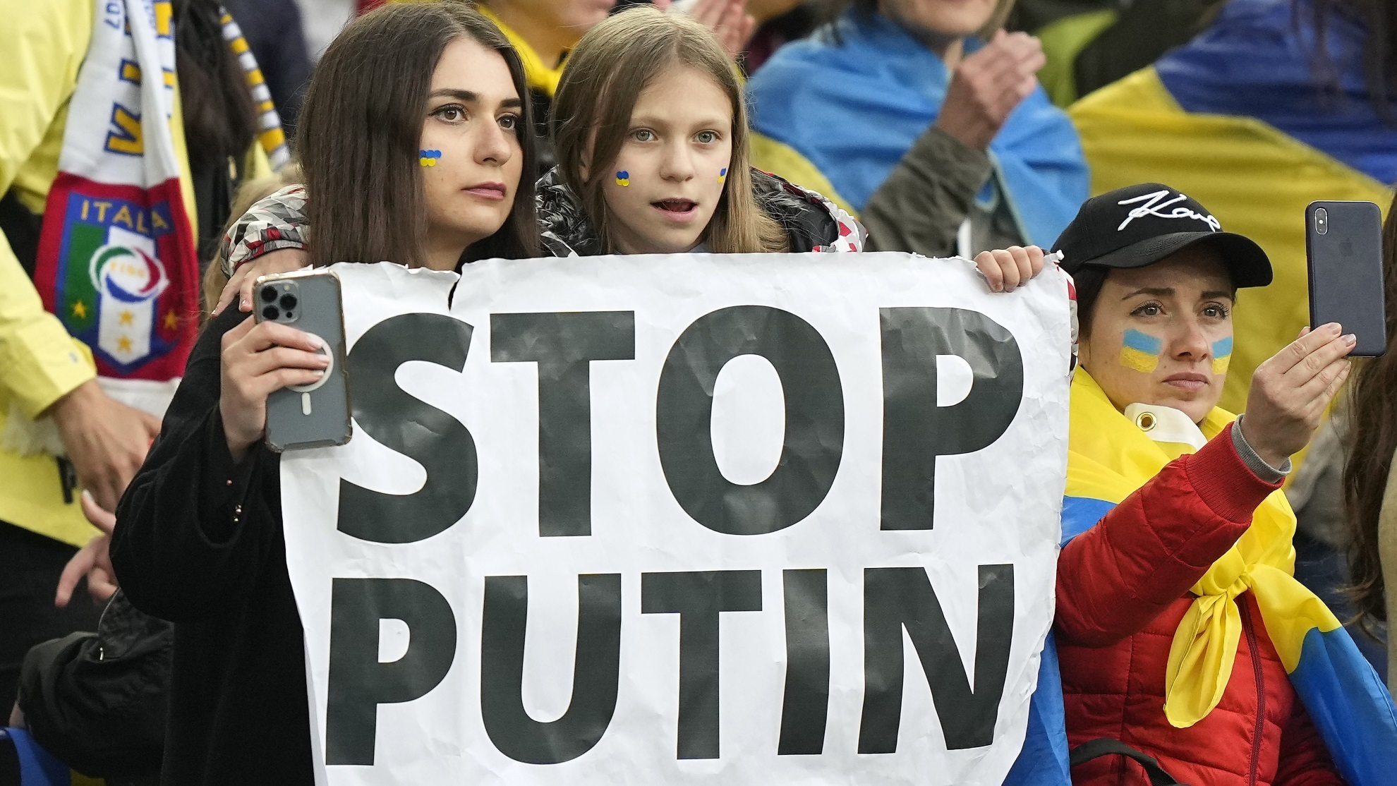 Supporters from Ukraine hold a banner reading "Stop Putin" during a charity soccer match.