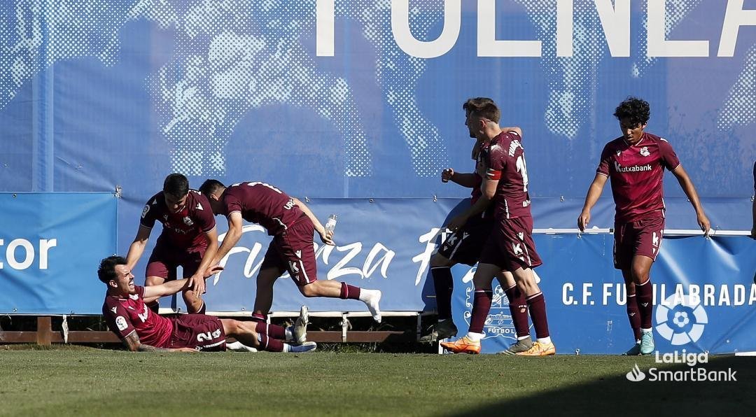 Alex Sola celebra su gol al Fuenlabrada tendido sobre el césped con sus compañeros.