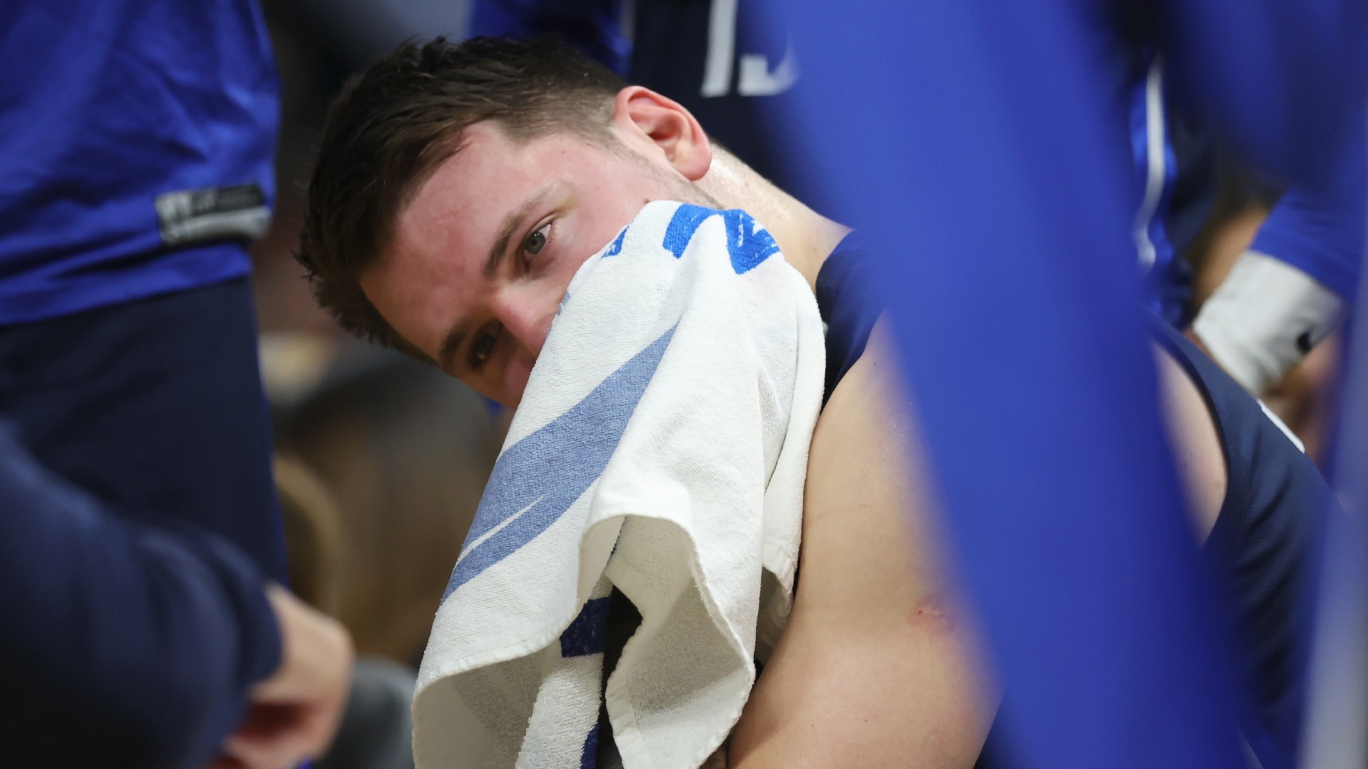 Luka Doncic se seca con una toalla en el banquillo de los Mavericks.